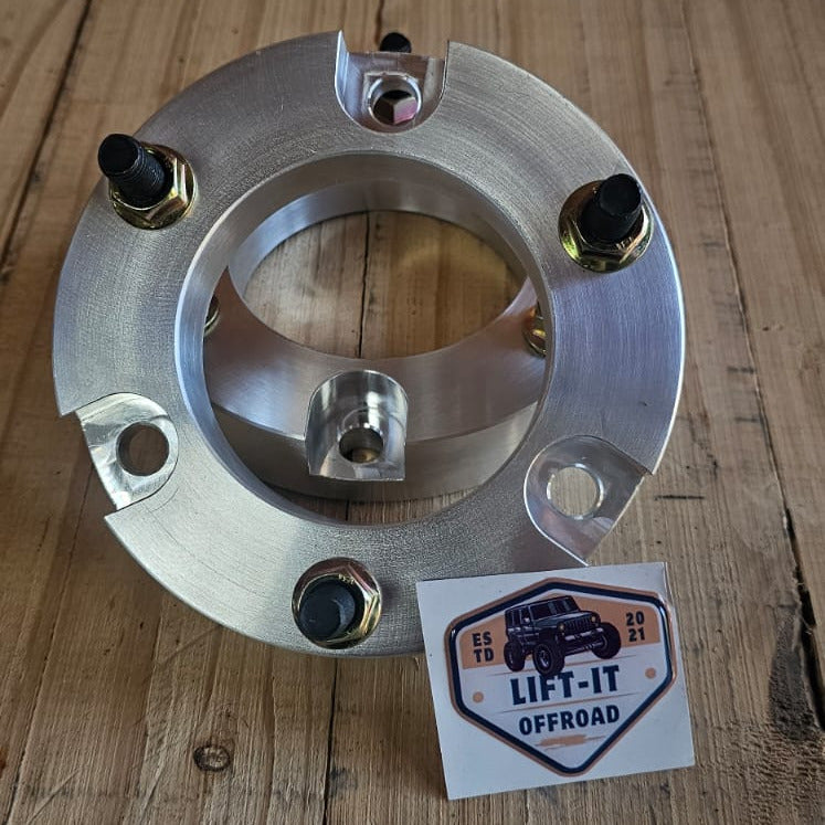 Metallic front strut spacers on a wooden surface with a 'LIFT-IT OFFROAD' label.
