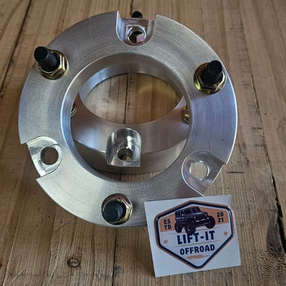 Metallic front strut spacers on a wooden surface with a 'LIFT-IT OFFROAD' label.